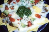 Hot tortilla chips topped with frijoles, salsa and cheese